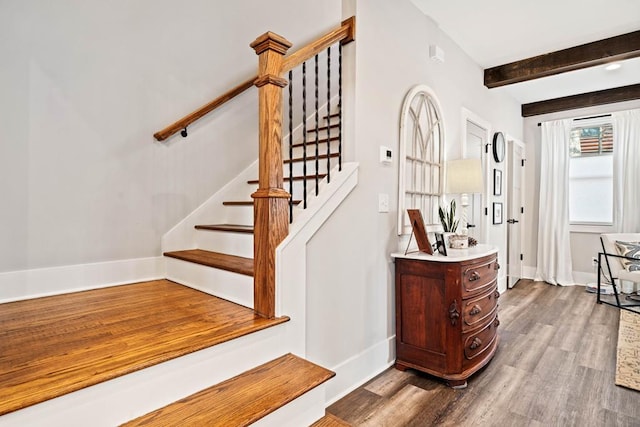 stairs with hardwood / wood-style flooring and beamed ceiling