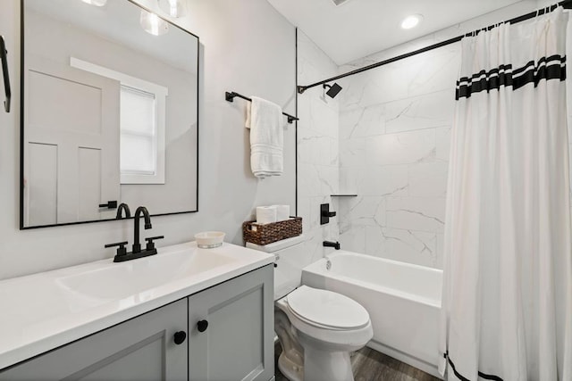 full bathroom featuring vanity, hardwood / wood-style flooring, toilet, and shower / bath combo with shower curtain