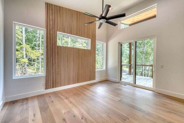 spare room with ceiling fan, light wood-type flooring, and a wealth of natural light