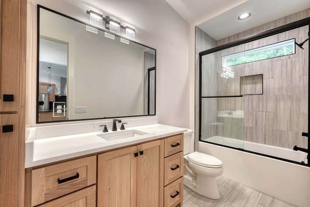 full bathroom with vanity, shower / bath combination with glass door, and toilet