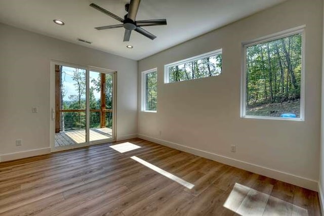 empty room featuring hardwood / wood-style flooring, plenty of natural light, and ceiling fan