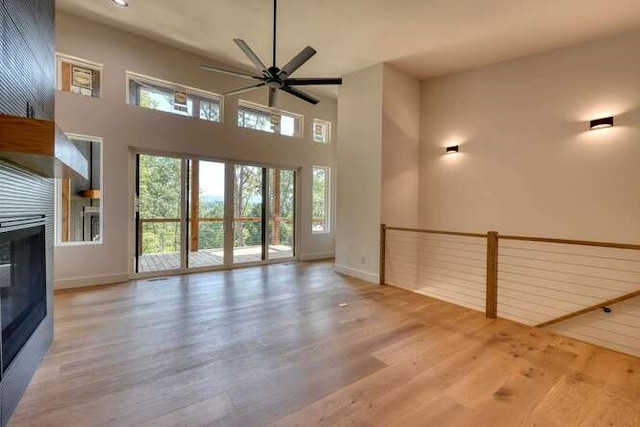 unfurnished living room with wood-type flooring and ceiling fan