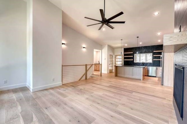 unfurnished living room featuring ceiling fan and light wood-type flooring