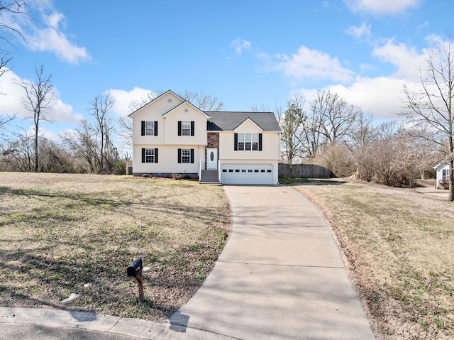 view of front of property featuring driveway, an attached garage, a front lawn, and fence