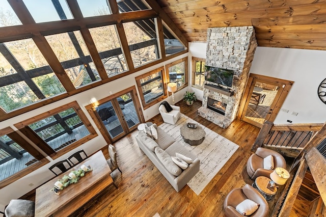 living room featuring wooden ceiling, a fireplace, beamed ceiling, hardwood / wood-style flooring, and high vaulted ceiling