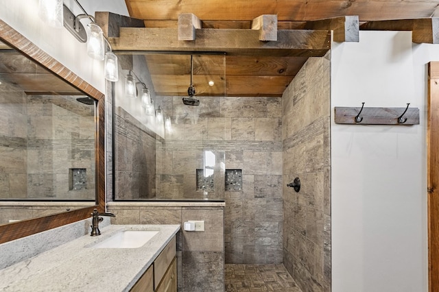 bathroom with tiled shower and vanity