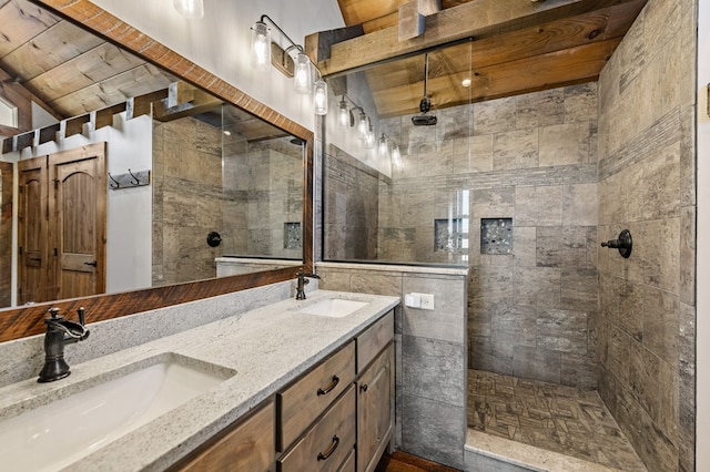 bathroom featuring a tile shower and vanity