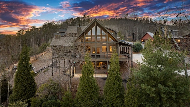 back house at dusk featuring a patio