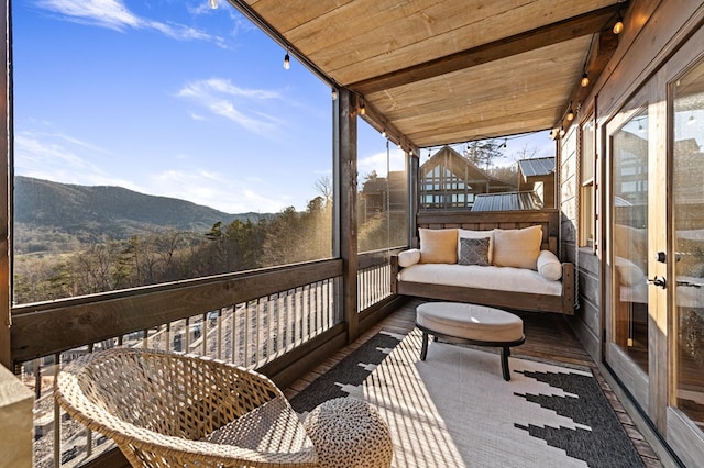 sunroom featuring wood ceiling, lofted ceiling, and a mountain view