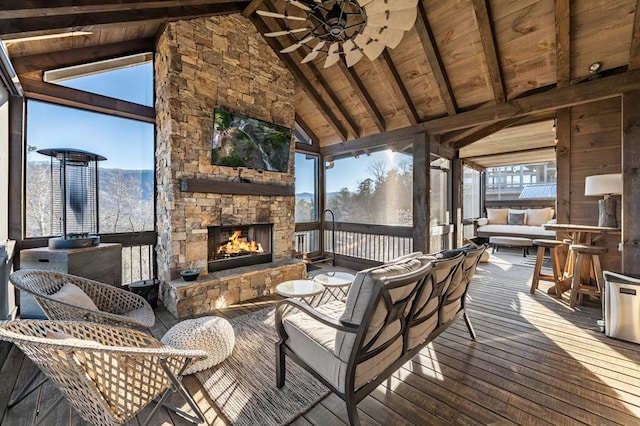 deck with ceiling fan and an outdoor living space with a fireplace