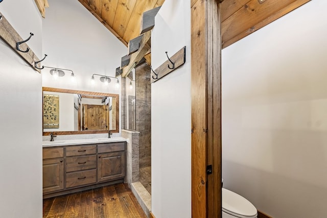 bathroom with wood-type flooring, walk in shower, vanity, and toilet