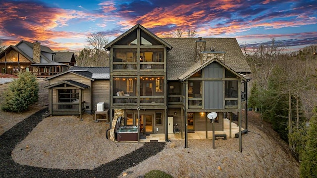 back house at dusk with a patio area