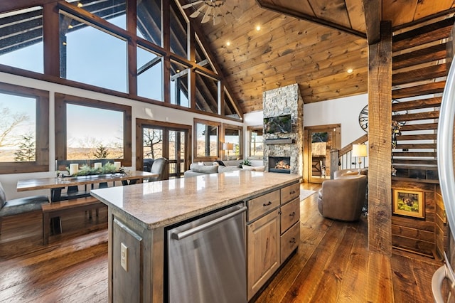 kitchen featuring a kitchen island, high vaulted ceiling, dishwasher, and a stone fireplace