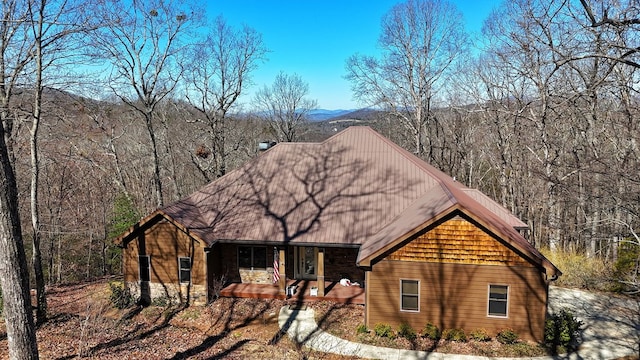 view of front of house with a forest view and a porch