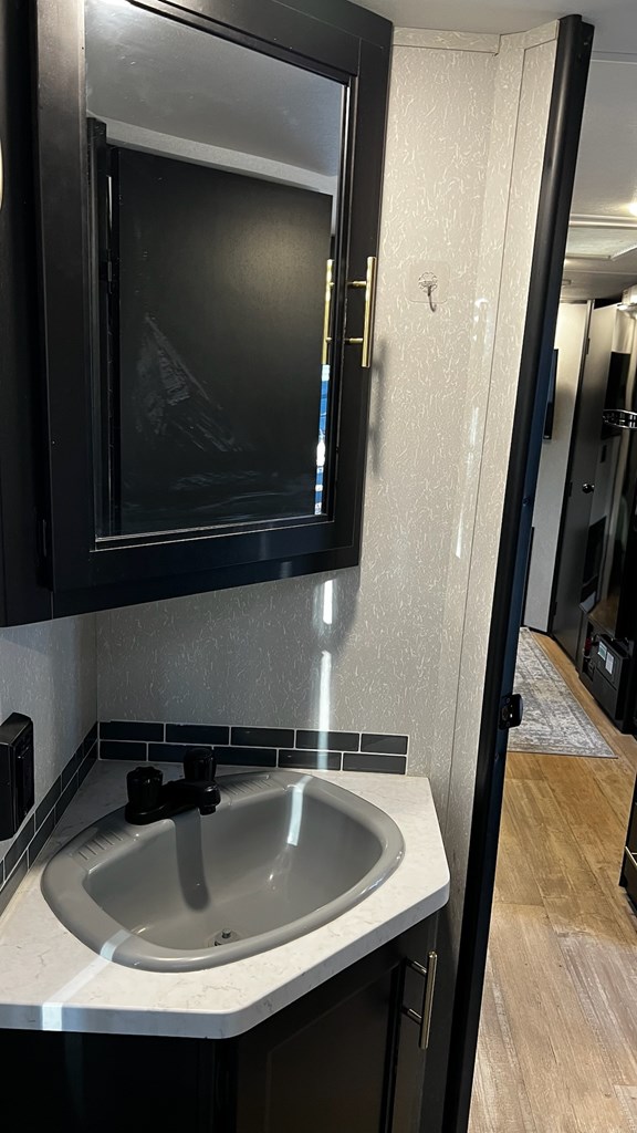 details with wood finished floors, vanity, and a textured wall