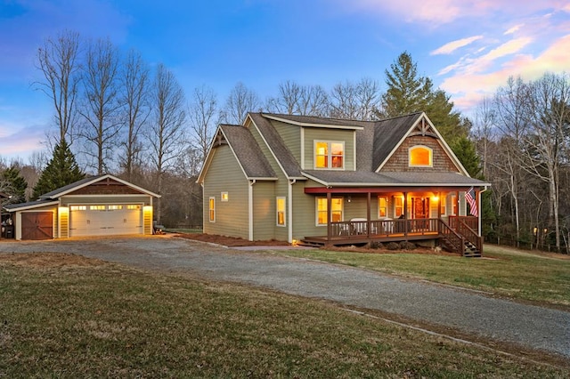 view of front of house featuring a porch, a shingled roof, a garage, driveway, and a front lawn