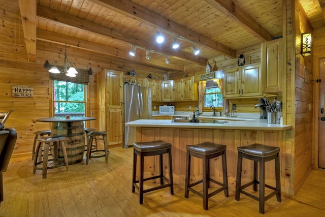 kitchen featuring light wood-style floors, wood ceiling, wood walls, and freestanding refrigerator