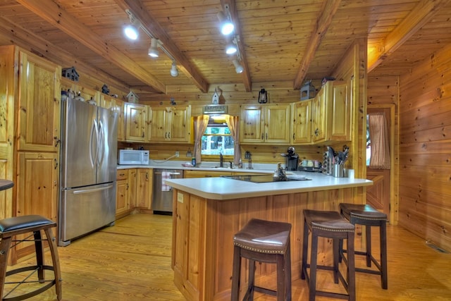 kitchen with wood ceiling, wooden walls, stainless steel appliances, and light wood-style floors