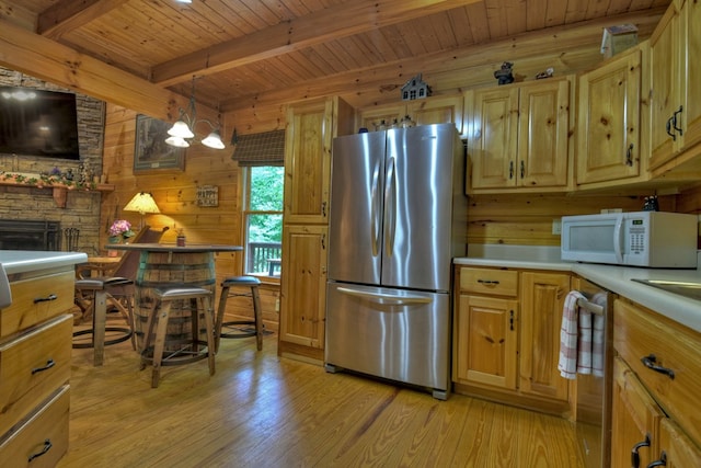 kitchen with beamed ceiling, appliances with stainless steel finishes, wood ceiling, and light wood-style floors