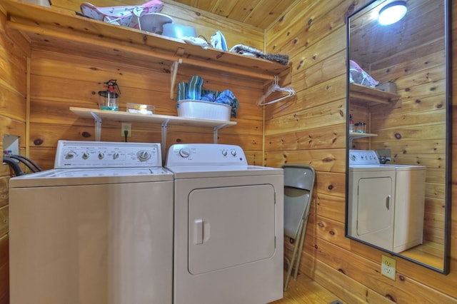 laundry room featuring wooden walls, washing machine and dryer, and laundry area