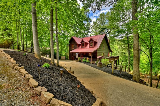 view of front of property with metal roof, a porch, and concrete driveway