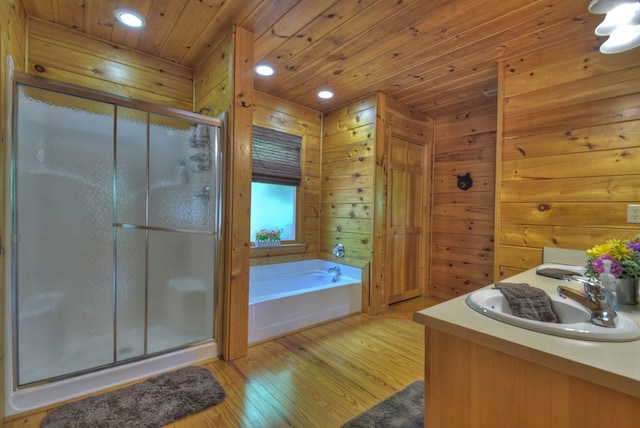 full bathroom featuring wood finished floors, a stall shower, a sink, wooden ceiling, and a bath