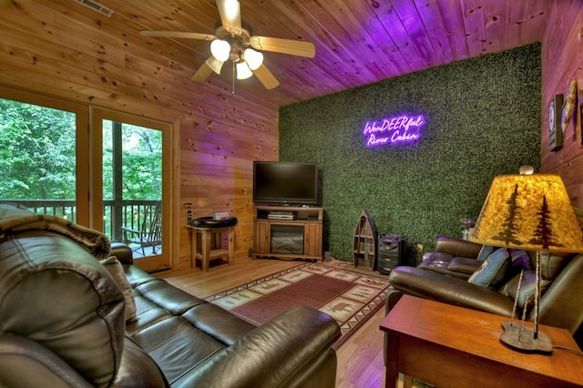 living area with ceiling fan, wood finished floors, and wooden ceiling