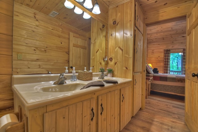 bathroom with wooden ceiling, wood finished floors, wood walls, and a sink