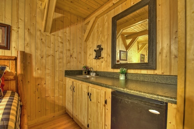 bar featuring a sink, wooden walls, wooden ceiling, and light wood finished floors