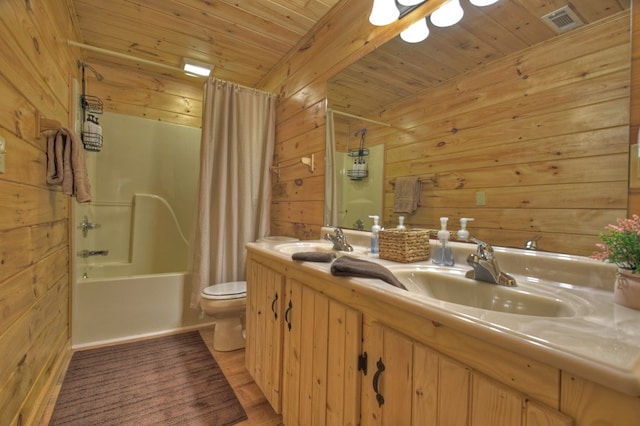 bathroom with visible vents, wood ceiling, wooden walls, and a sink