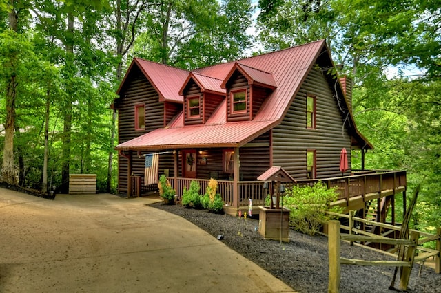 log home featuring a porch and metal roof