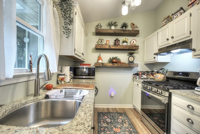 27 Ivy St, Ellijay, GA 30540 - kitchen with stainless steel appliances, under cabinet range hood, a sink, light wood finished floors, and white cabinets