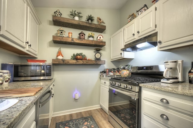 27 Ivy St, Ellijay, GA 30540 - kitchen featuring appliances with stainless steel finishes, under cabinet range hood, light wood-style floors, open shelves, and baseboards