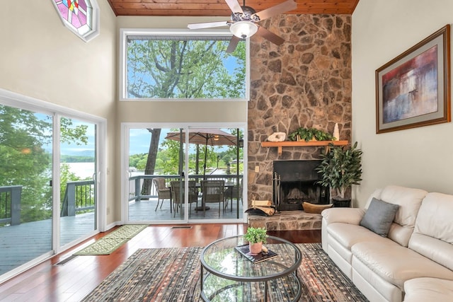 living room featuring a ceiling fan, hardwood / wood-style flooring, high vaulted ceiling, wooden ceiling, and beamed ceiling