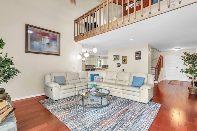 living area featuring stairway, baseboards, and wood finished floors