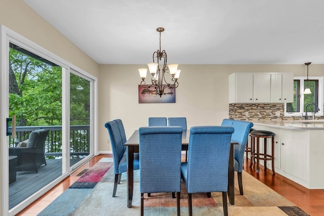 dining room featuring healthy amount of natural light, a chandelier, and light wood-type flooring