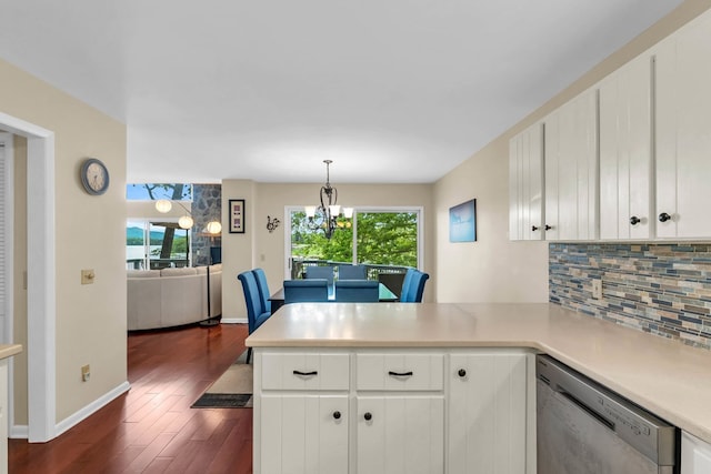 kitchen featuring dishwasher, a peninsula, healthy amount of natural light, and decorative backsplash