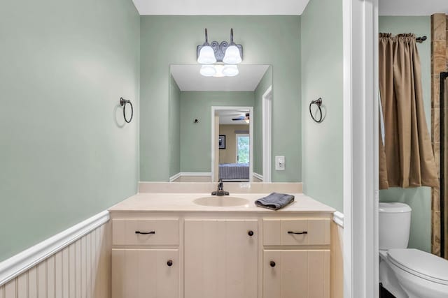 bathroom with toilet, vanity, and a ceiling fan