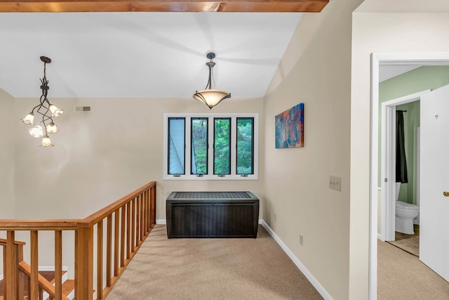corridor featuring carpet floors, vaulted ceiling, baseboards, and a chandelier