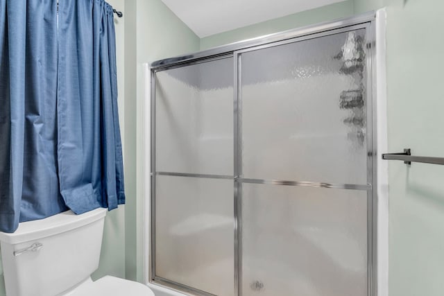bathroom featuring a shower stall and toilet