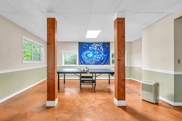 office space featuring finished concrete flooring, baseboards, and a paneled ceiling