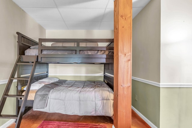 bedroom with a drop ceiling and baseboards