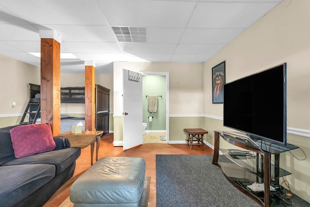 living room with a paneled ceiling and baseboards