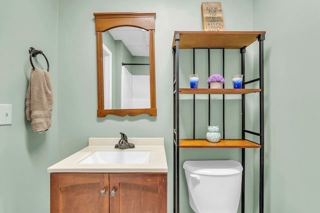 bathroom with vanity, toilet, and a shower