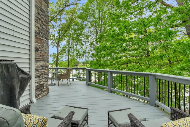 wooden terrace with a grill and outdoor dining area