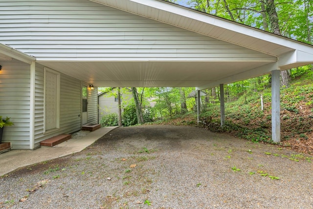 view of parking / parking lot featuring entry steps, a carport, and gravel driveway