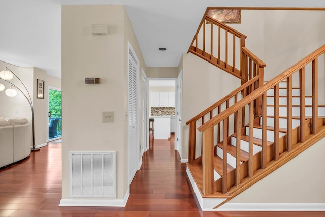 staircase featuring wood finished floors and baseboards