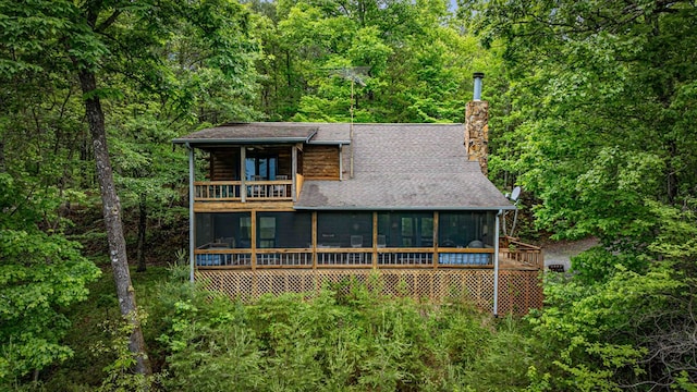 35 The Blf, Morganton, GA 30560 - view of front facade with a sunroom, a balcony, a chimney, and a view of trees