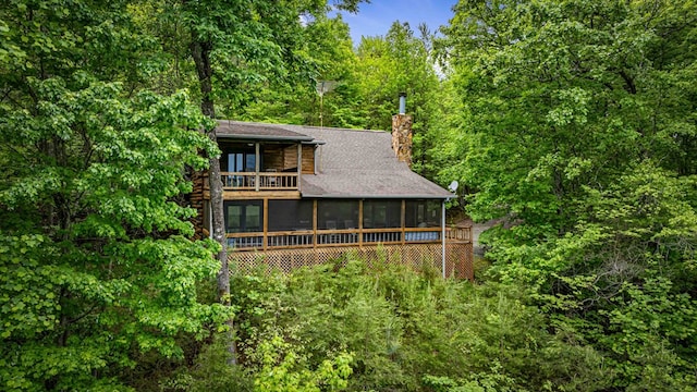 35 The Blf, Morganton, GA 30560 - back of house featuring a sunroom, a balcony, a chimney, a forest view, and roof with shingles