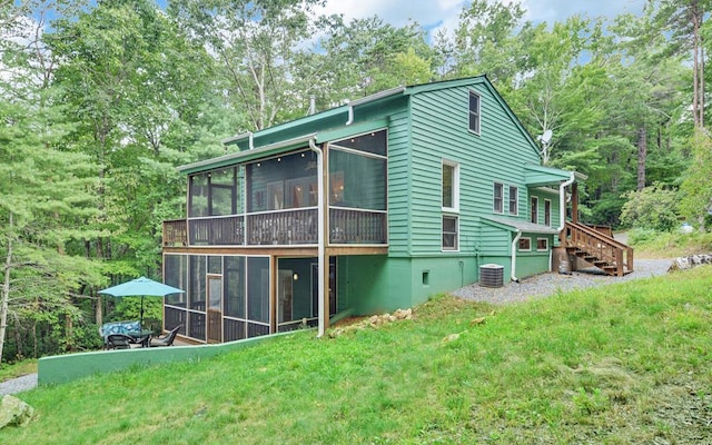 view of side of home with a lawn, a sunroom, and central air condition unit